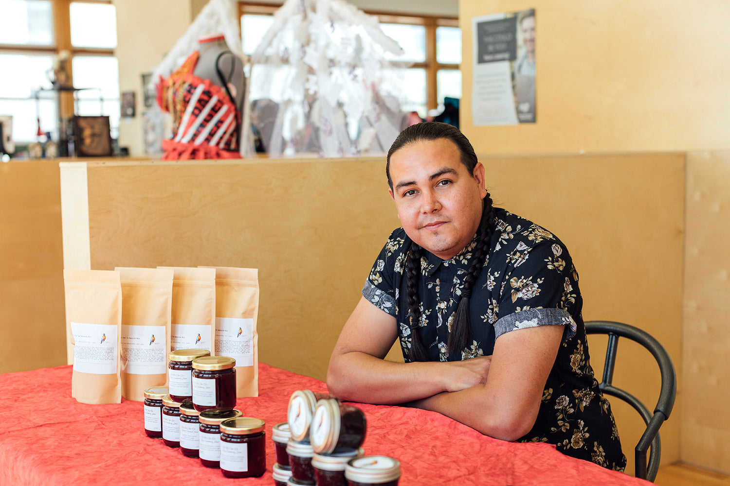 Pei Pei Chei Ow founder, Scott Jonathan Iserhoff, at a farmer's market with his jams, bannock mix, and BBQ sauces