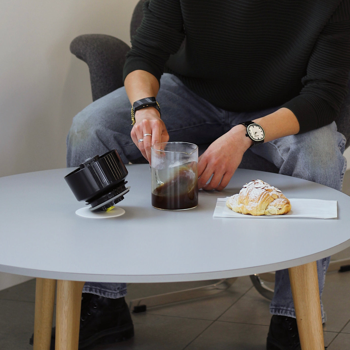 Close-up of Karine Ng's hand swirling the VacOne carafe of coffee