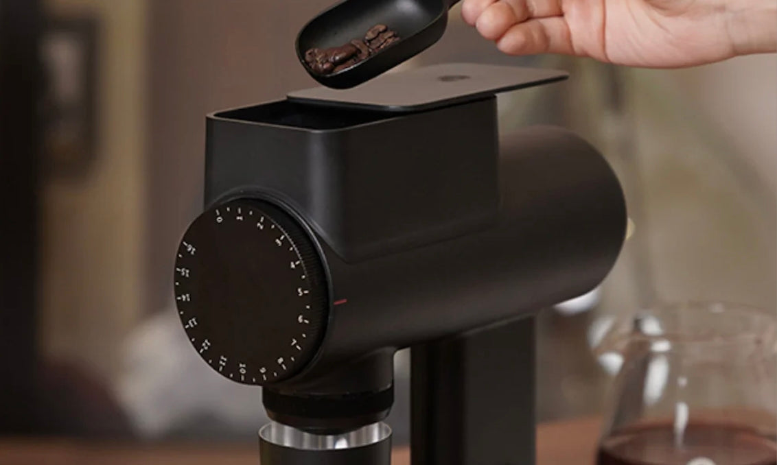 espresso beans being poured into a Timemore Sculptor 064 grinder