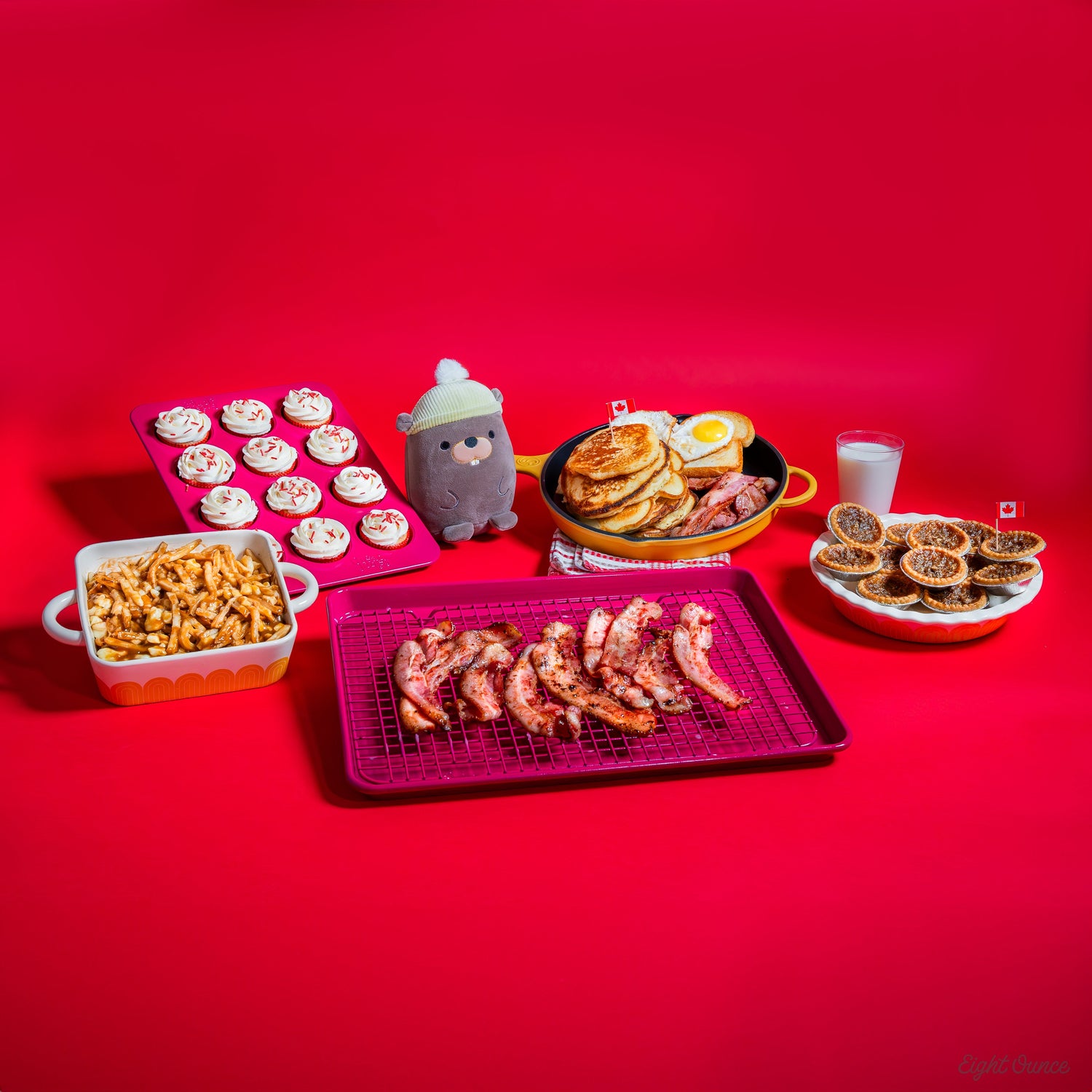 Great Jones Baking Try, Cupcake Tray, and Pan behind a red background